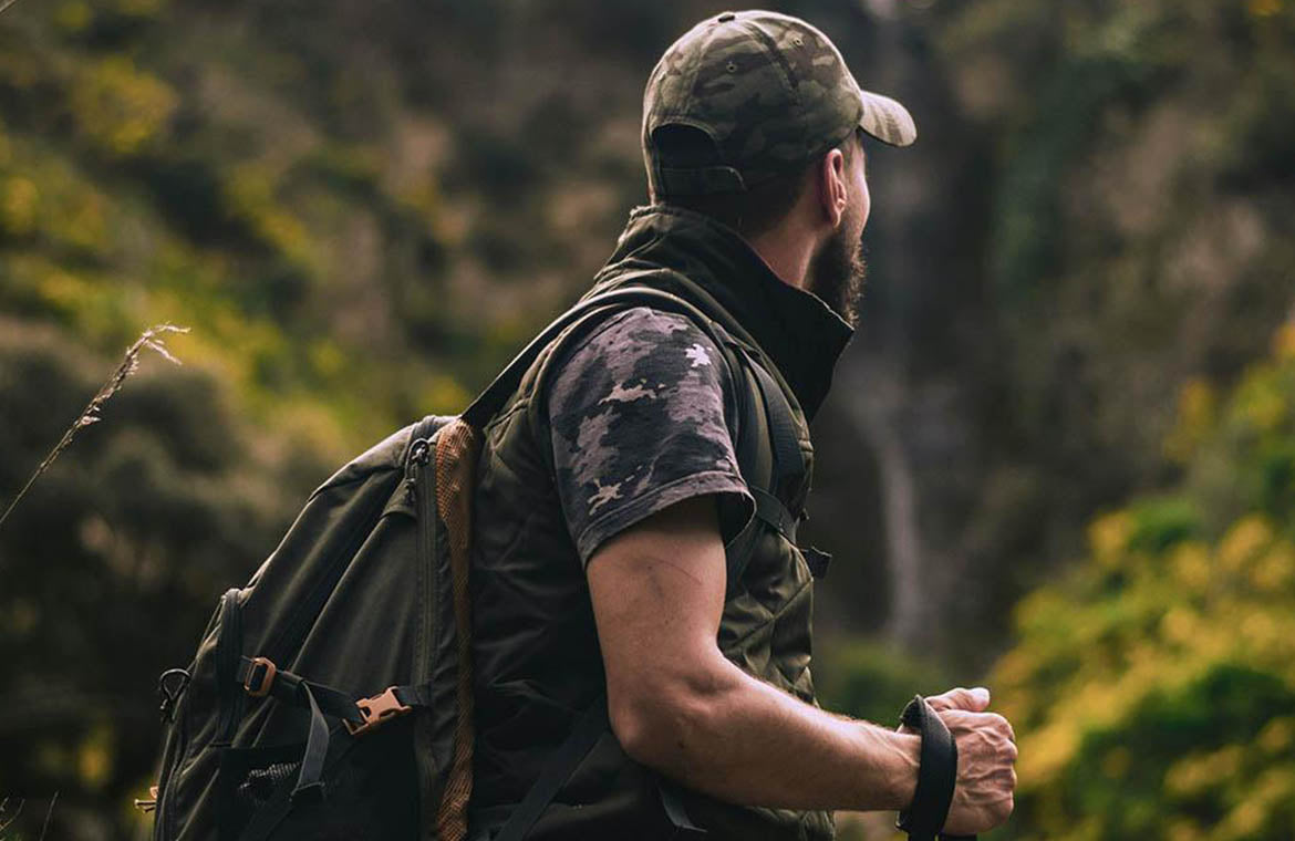 A man in a camouflage T-shirt is hiking