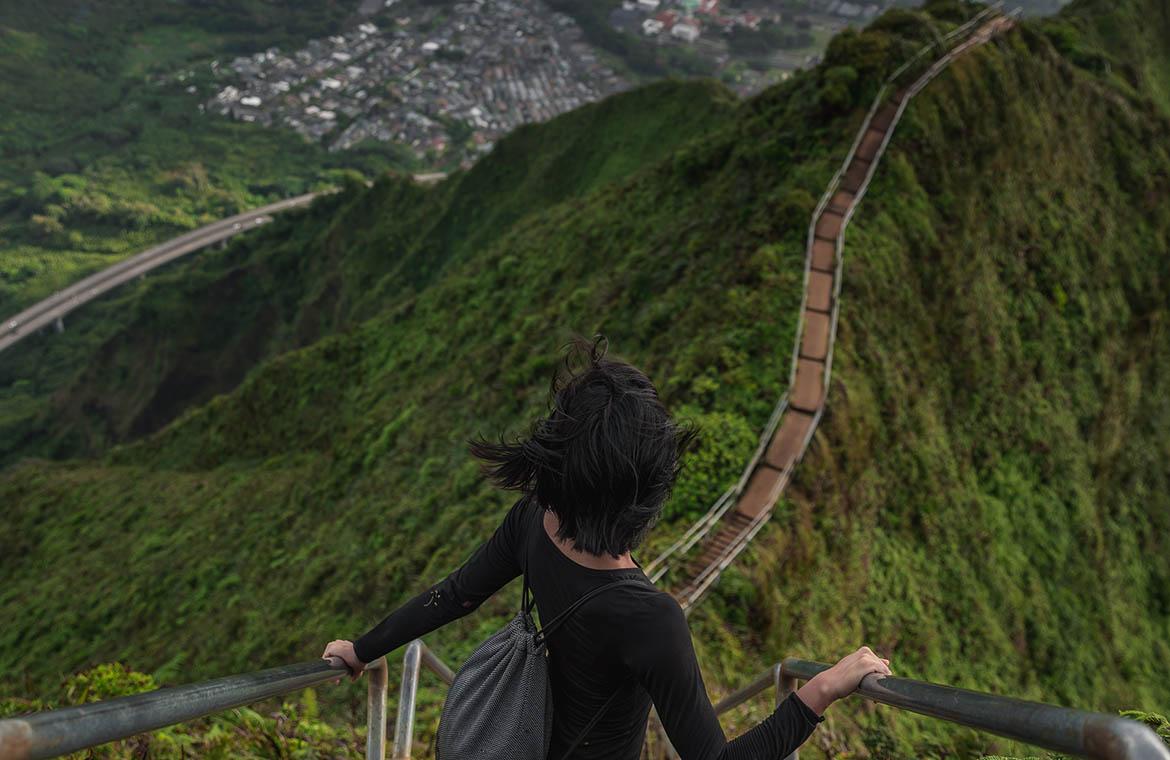 A woman is exploring on a rope bridge on top of a mountain